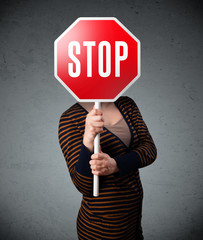 Young woman holding a stop sign