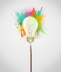 Pen close-up with colored paint splashes and lightbulb