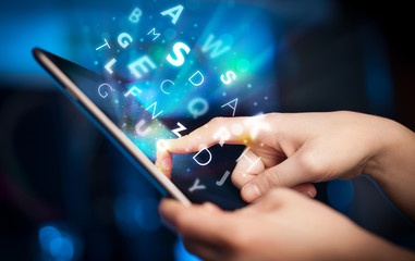 Finger pointing on tablet pc, letters concept
