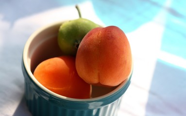 juicy peaches in a blue bowl