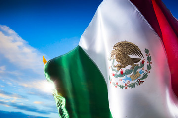 Obraz na płótnie Canvas Mexican flag against a bright sky, independence day, cinco de ma