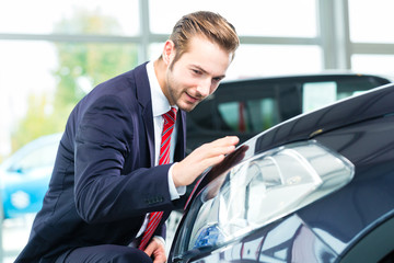 Verkäufer mit Auto im Autohaus