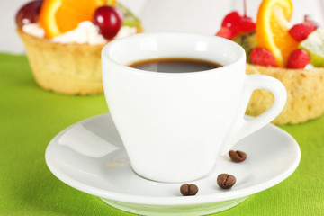 cup of coffee and sweet cakes with fruits on wooden table