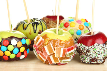 Candied apples on sticks on wooden table close up