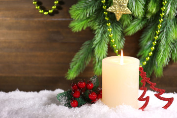 Burning candle on wooden background
