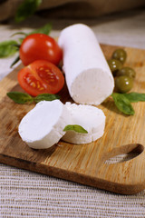 Tasty bushe cheese with tomatoes, olives and basil,
