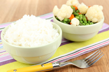 Cooked rice with vegetables on wooden table close up