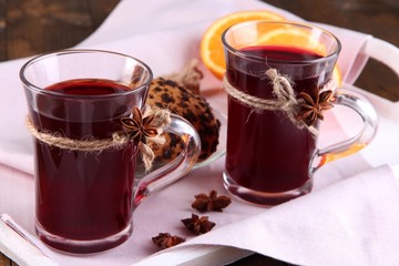 Mulled wine with cookies on table close up