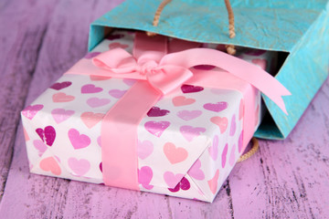 Present with paper bag on wooden background