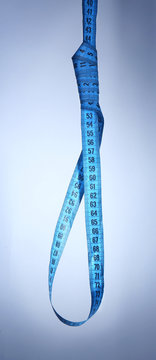 Tape measure noose on blue background - diet concept