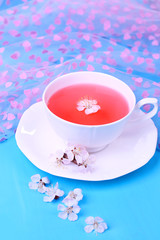 Fragrant tea with flowers on wooden table close-up