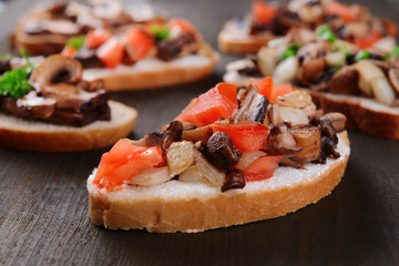 Delicious bruschetta with mushrooms on table close-up