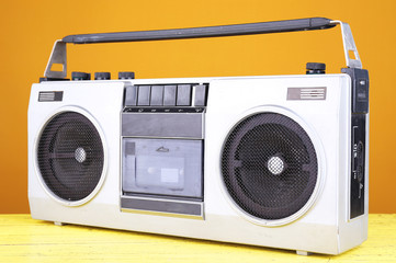 Retro cassette stereo recorder on table on yellow background
