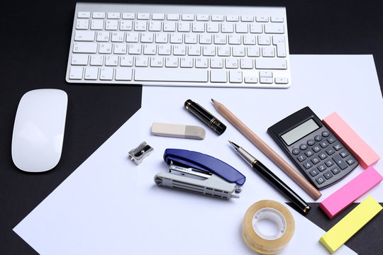 Office table with stationery accessories, keyboard and paper,