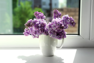 Beautiful lilac flowers on windowsill