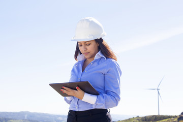 Female engineer working with a tablet at wind farm