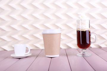 Assortment of coffee drinks on wooden table, on light