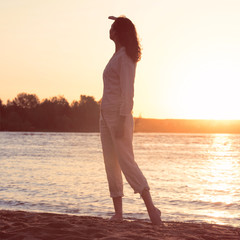 Fototapeta premium Beautiful woman looking to the golden sunshine