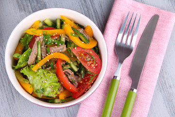 Beef salad in bowl on wooden background