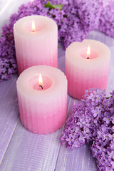 Obraz na płótnie Canvas Beautiful lilac flowers with candles on table close-up