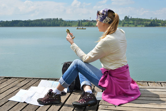 Traveler with a compas on the wooden jetty