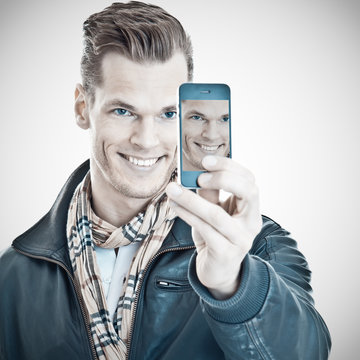 Lächelnder junger Mann macht sein Selfie