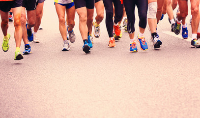 Unidentified marathon athletes legs running on street 