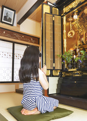 仏壇に手を合わせる女の子