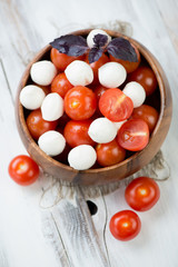 Mozzarella and tomatoes in a wooden bowl, above view