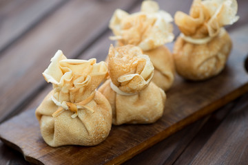 Crepes with stuffing on a rustic wooden cutting board