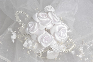 White boutonniere on bridal veil on gray