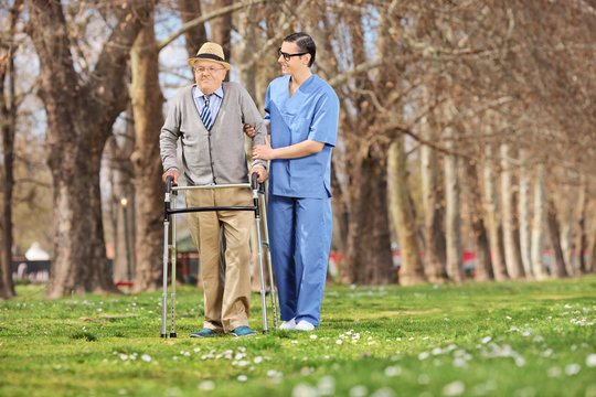 Medical professional helping a senior in park