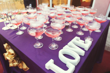 Many glasses of red drink on table