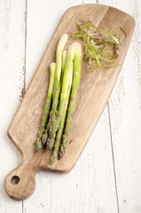 raw asparagus on a wooden board