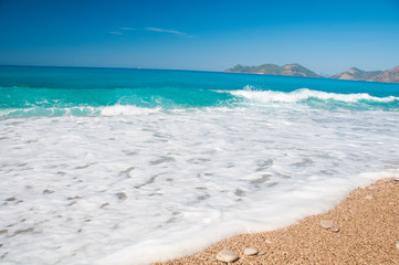 Beautiful surf on the beach. Mountains on the horizon.