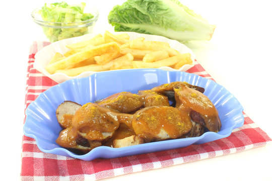 Currywurst mit Pommes Frites auf einer Serviette