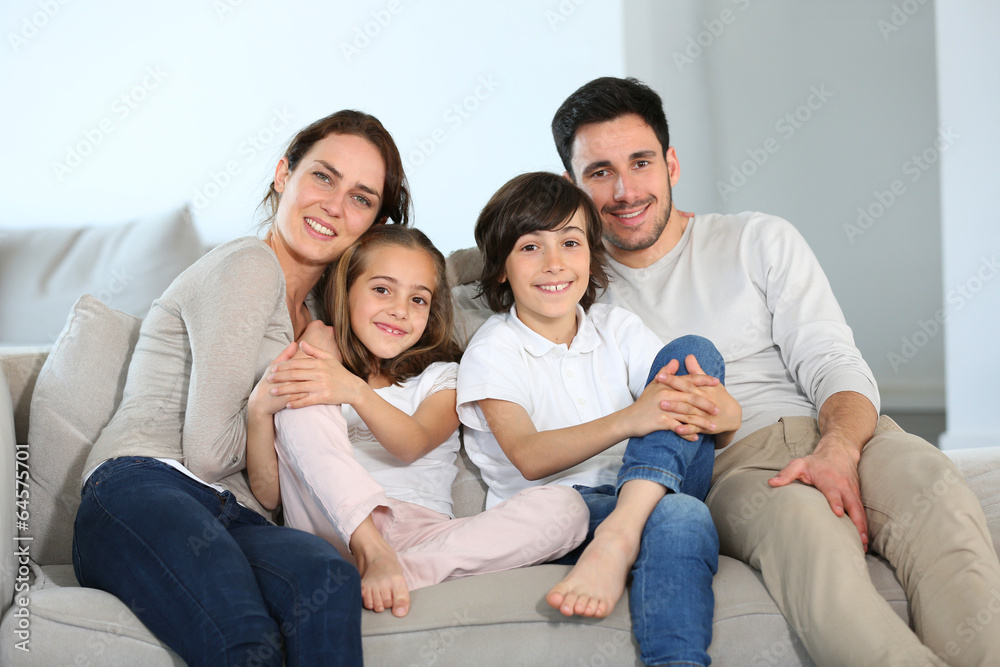 Wall mural Happy family sitting together in couch