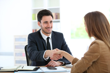 Woman giving handshake to financial adviser