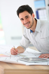 Architect in office drawing construction blueprint