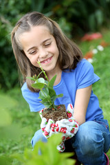 Little girl holding plant ready to be earthed