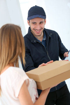 Smiling delivery man giving cardbox to customer
