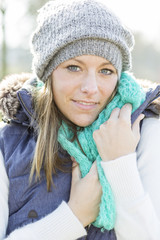 Junge Frau im kuschligen Outfit mit gestrickter Schal und Mütze