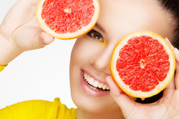 Young brunette with red grapefruit in her hand