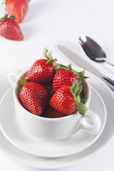Festive table set with strawberry in bowl on white background