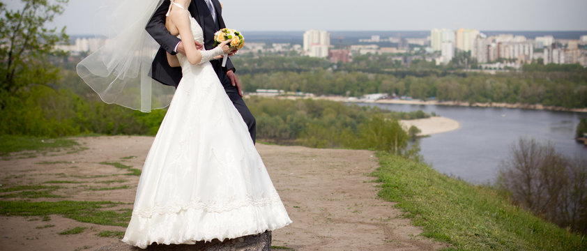 Married couple standing on top of hill