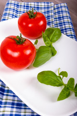 Basilikum mit Tomaten auf Schale mit Serviette