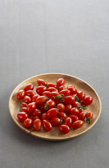 many tomato on wooden plate in natural light