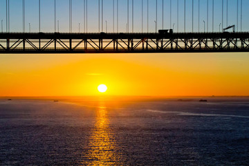 Fototapeta premium Sunrise and silhouette of 25th of April bridge