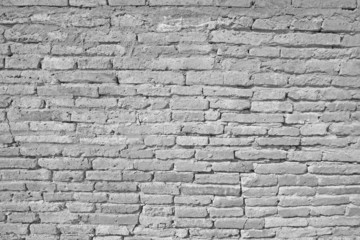 Vintage white brick wall with cracked concrete