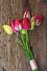 bouquet of multi-colored tulips on a wooden surface